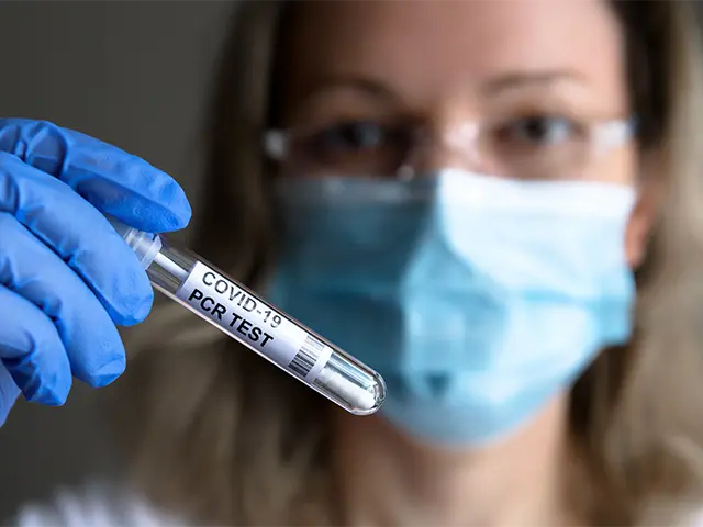 Pharmacist holding a COVID test vial