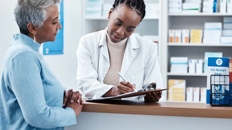 pharmacist explaining medication to elderly patient - Medicare Part D